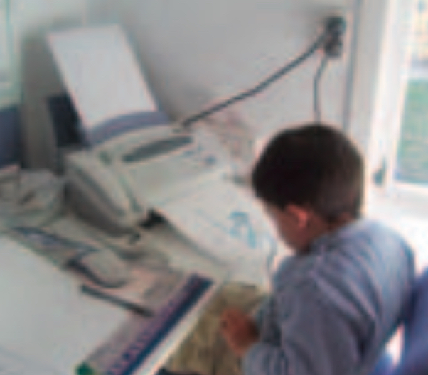Boy using fax machine
