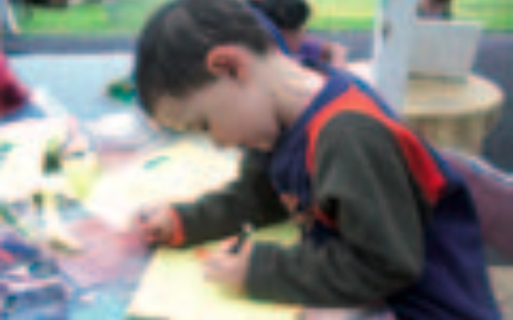 Boy writing on piece of paper