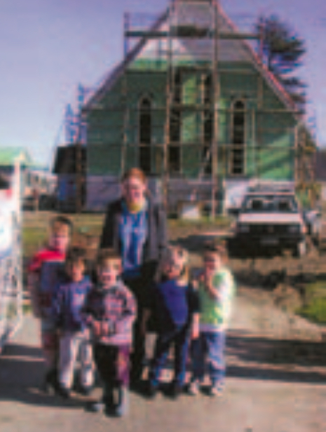 Red-haired woman and five children outside a church