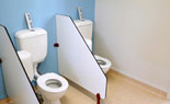 Toilets with half height walls and separate private toilet.