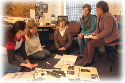 Collaboration image, five teachers around documents
